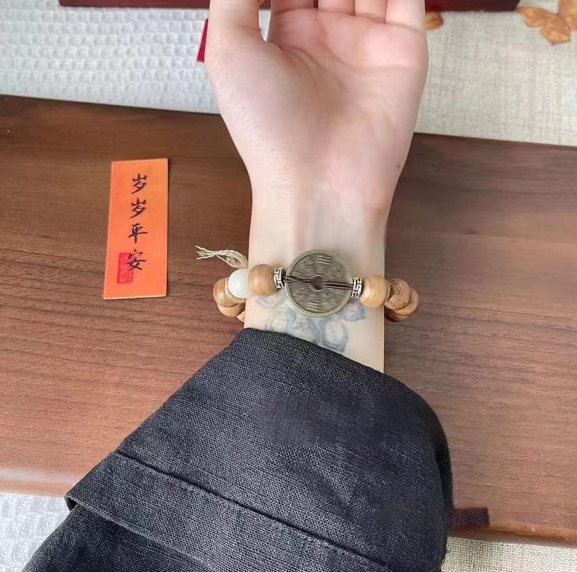 Mountain Ghost - Evergreen Harmony Bracelets with wood beads and coin charm on wrist.