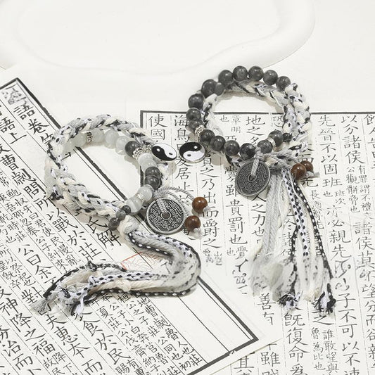 Mountain Ghost Yin-Yang Ripple Bracelets with fluid beadwork and charms on a textured background.